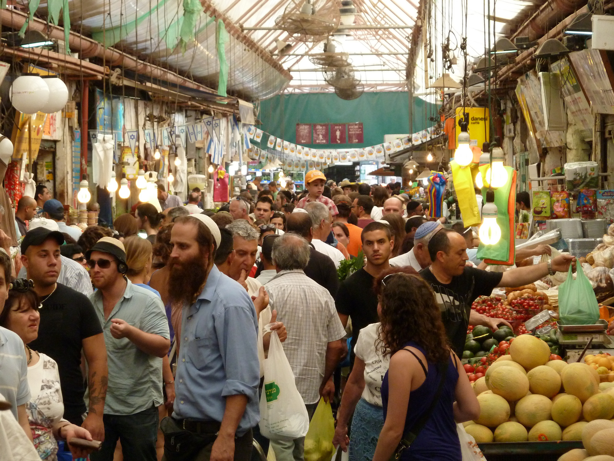 Frequentadores do mercado Mahane Yehuda, em Jerusalém, incluindo judeus religiosos e seculares no cotidiano, 2011.