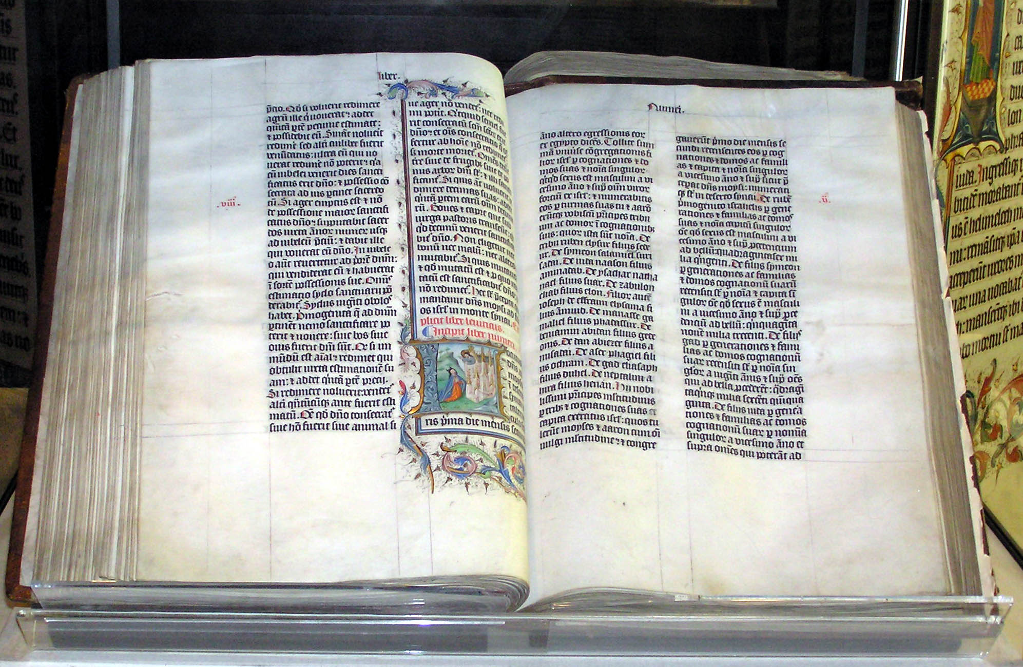 Bíblia de Malmesbury, manuscrito medieval iluminado aberto, exibindo texto em latim e miniatura colorida, exemplo da Palavra escrita.